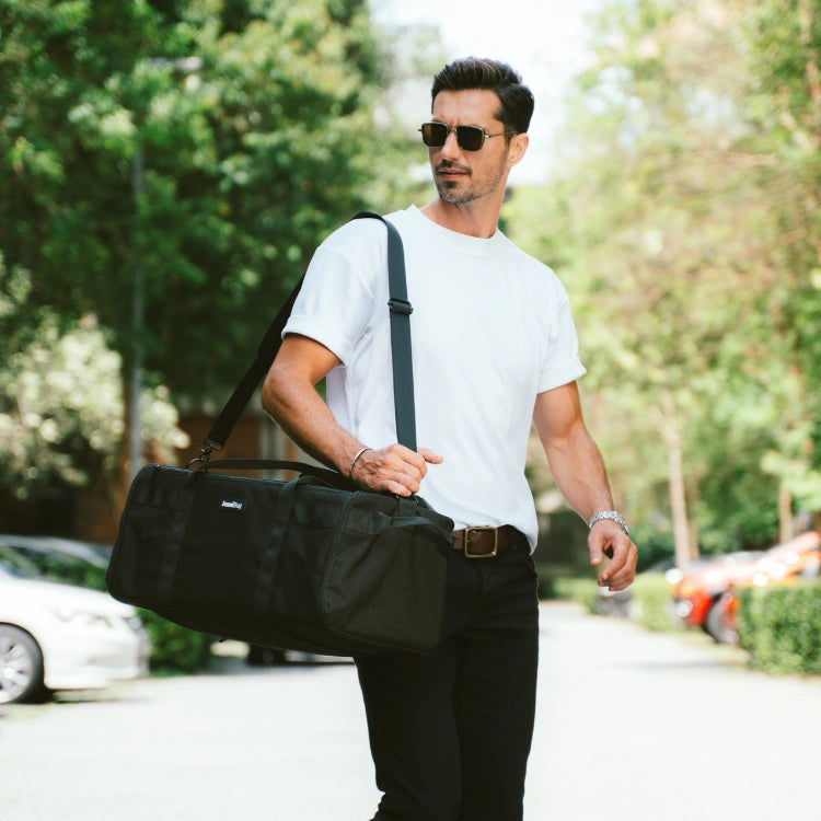 Traveler carrying a black JenniBag 2.0 over the shoulder outdoors