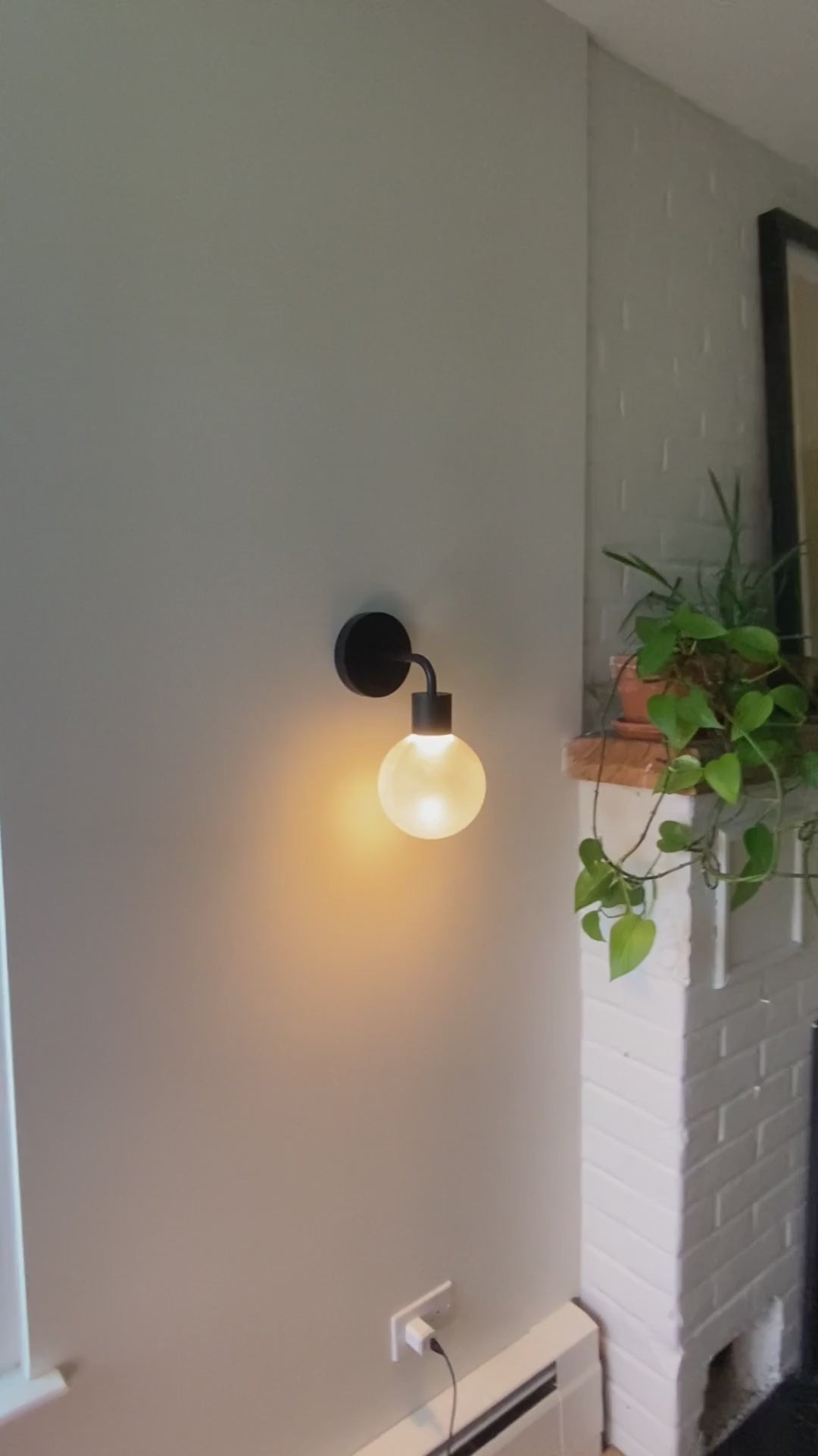 Matte black Poplight rechargeable wall sconce mounted on a wall