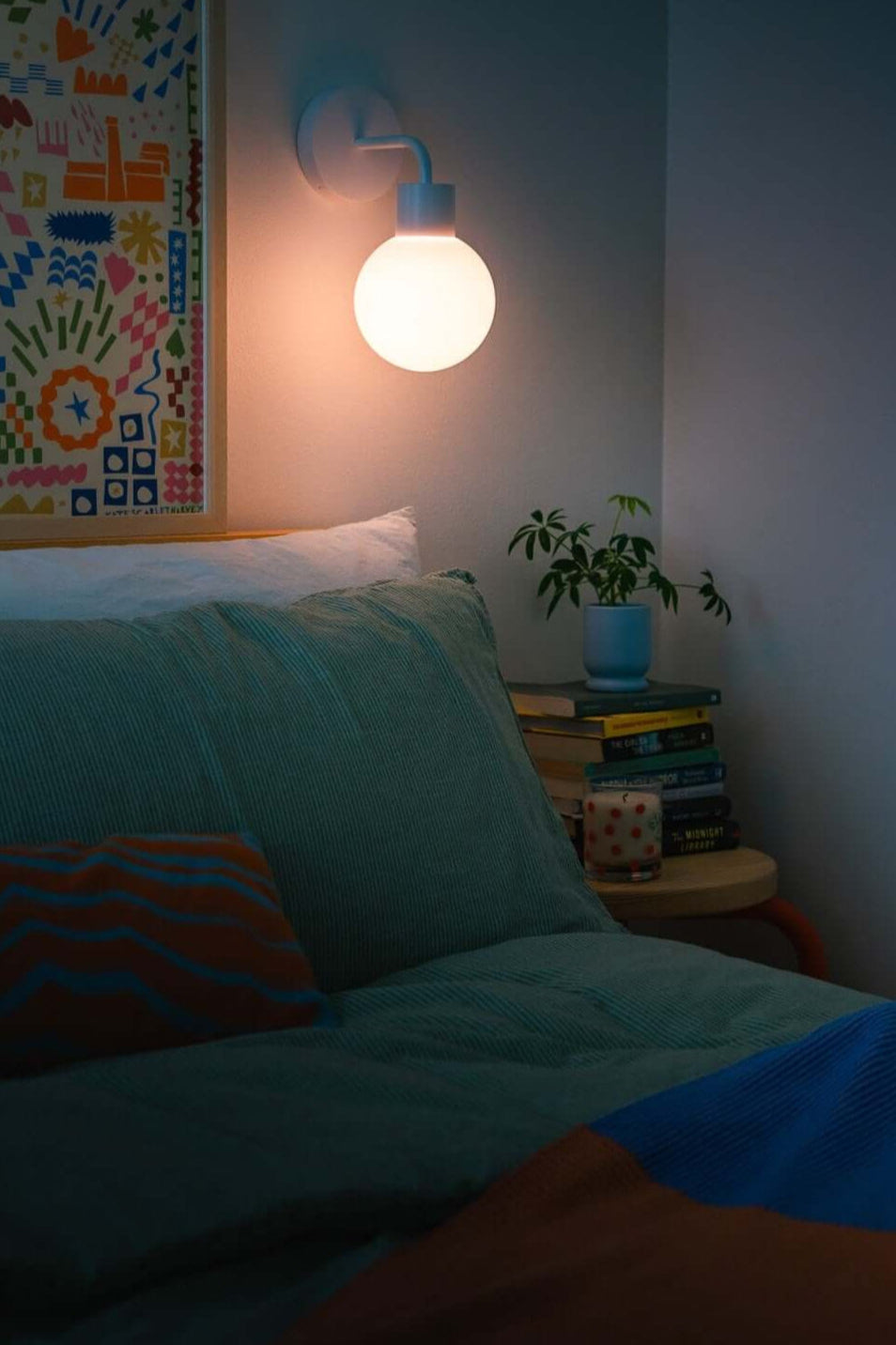 Poplight wall sconce providing warm bedside lighting in a bedroom